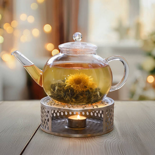 Glazen theepot met bloementhee op RVS theewarmer met kaarsje