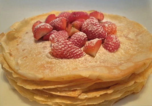 Stapel pannenkoeken met verse aardbeien en poedersuiker Nederlands recept