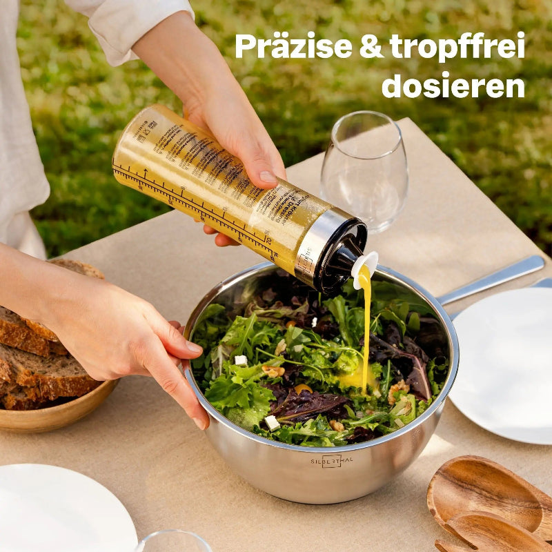Dressing wordt met de schenktuit van de Silberthal glazen dressingmixer over een salade gegoten.