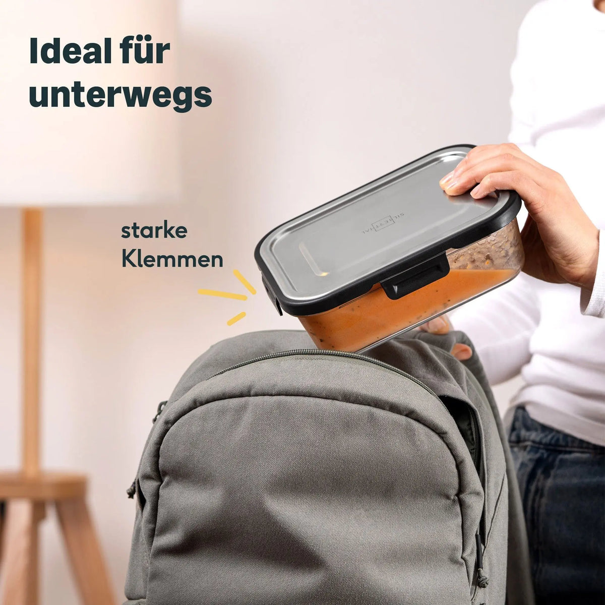 Silberthal glazen lunchbakje met RVS deksel en sluitclips wordt in een rugzak gestopt.