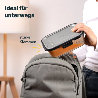 Silberthal glazen lunchbakje met RVS deksel en sluitclips wordt in een rugzak gestopt.
